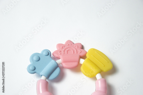 Close up of a colorful silicone baby teething ring toy with textured chewable parts isolated on a plain white background