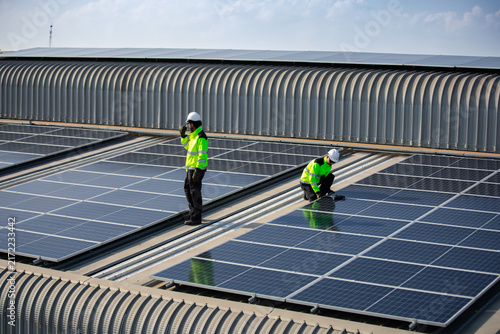 Foto Solar energy technicians inspect and maintain photovoltaic panels on a commercial rooftop, supporting renewable electricity, clean power generation and sustainable building technology
