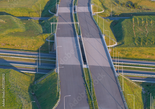 Aerial view of the Kashubian Route S6 Expressway featuring a multi-level highway interchange with grassy embankments and street lighting in Chwaszczyno, Pomeranian Voivodeship, Poland.