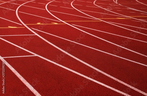 Red running track with white lines curving into the distance