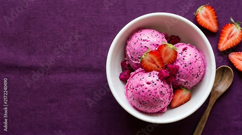 Refreshing strawberry ice cream scoops in a white bowl on a purple background