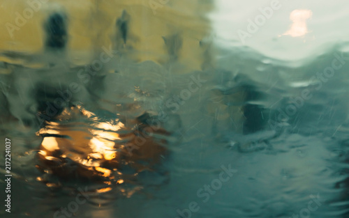 View during a storm. Headlights of passing car