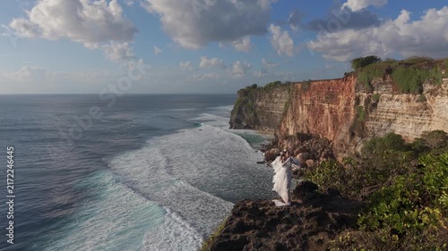 Drone Flyby of Woman Playing Violin on Dramatic Cliff Above the Ocean, Bali, Indonesia.