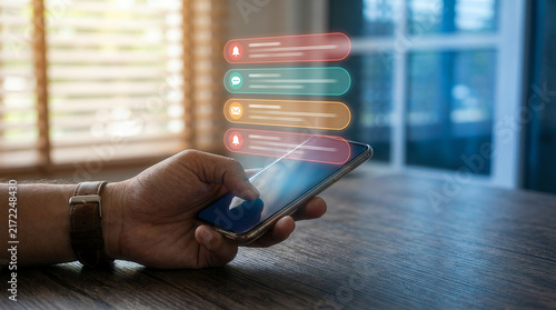 Hand holding smartphone with glowing notification alerts