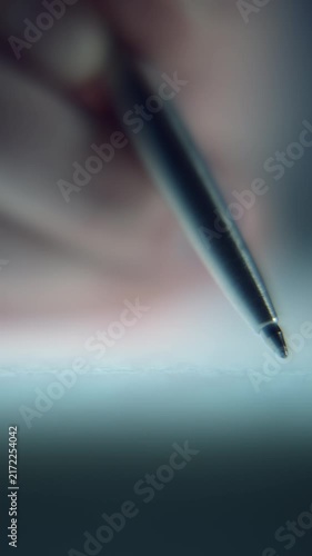 Extreme close-up footage of a man's hand signing an important document with a pen, captured with a shallow depth of field and cinematic focus. Conceptual footage representing contracts signing.