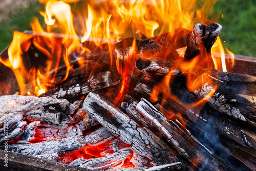 Fotografie Hot glowing embers and fire flames in barbecue grill, charcoal wood burning and