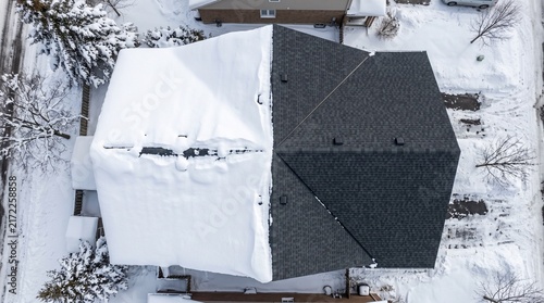 Split Aerial View of House Roof with Snow and Dark Shingles