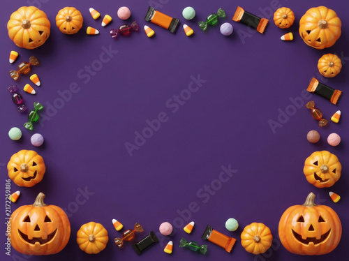 Halloween candy and pumpkin full frame border on purple background