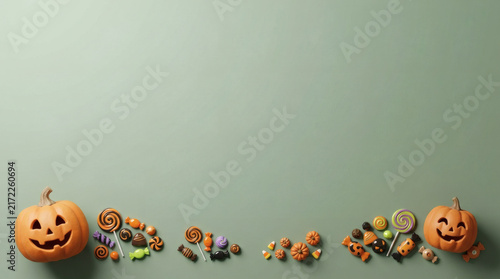 Panoramic Halloween candy and pumpkin border on sage green background