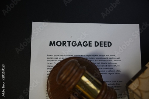 Wooden judge gavel resting on a mortgage deed document