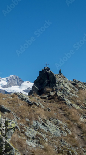 Summit cross on Monte Facciabella with snow-capped Monte Rosa in the background, Aosta Valley, Italy
