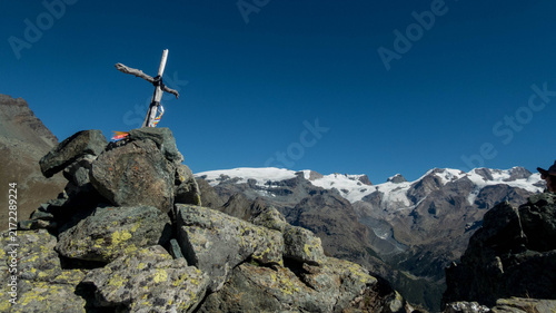 Summit cross on Monte Facciabella with snow-capped Monte Rosa in the background, Aosta Valley, Italy