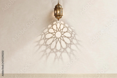 Islamic lantern hanging against beige wall casting beautiful geometric star pattern shadow