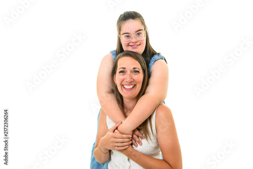child girl with Down syndrome over white background with his mother