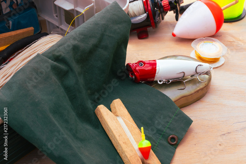 Canvastavla Fishing gear arranged on a wooden surface, showing lures, fishing line, bobbers,