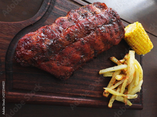 Fotografie costilla, papas a la francesa y elote a la parrilla presentado en tabla de parot