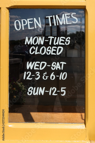 Open Times sign glass on yellow wooden frame