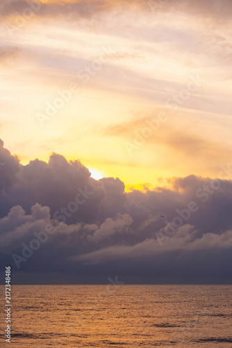 Bild auf Leinwand The scene shows the ocean at sunset with vibrant colors in the sky