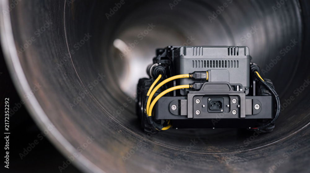 Fototapeta premium Autonomous pipeline inspection robot inside industrial metal pipe with cameras and cables