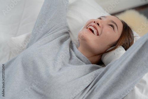 Fotografía Music relaxation concept with happy young woman wearing headphones while lying o