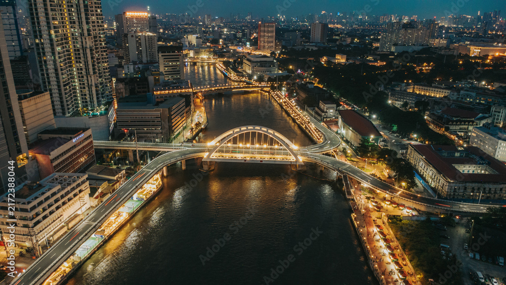 Obraz premium Aerial view of Binondo-Intramuros Bridge and Manila cityscape over Pasig River at night in the Philippines