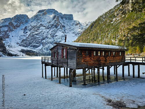 Obraz na plátně Lake Braies (Pragser See) in South Tyrol in winter, view of snowy mountain and Lake, Snow-covered wooden hut on stilts beside frozen lake