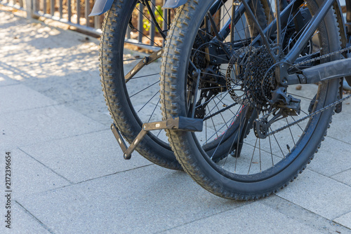 Fotografie Close up of two bicycles locked securely with folding lock on urban sidewalk