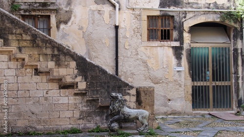 Фотография Stone lion statue and staircase in a historic courtyard in Ortigia, Syracuse, Si