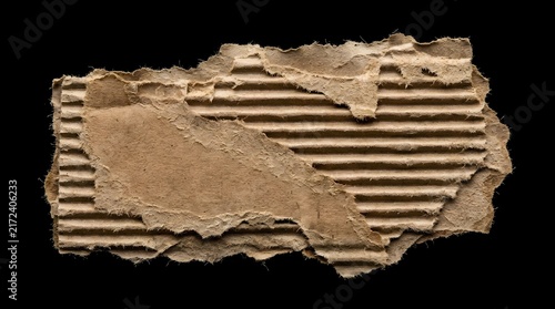 Torn brown corrugated cardboard piece isolated on a black background