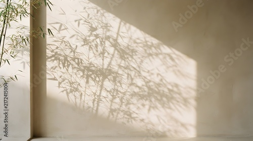 Delicate bamboo leaves cast artistic shadows across a smooth beige wall creating a serene minimalist atmosphere in soft natural daylight
