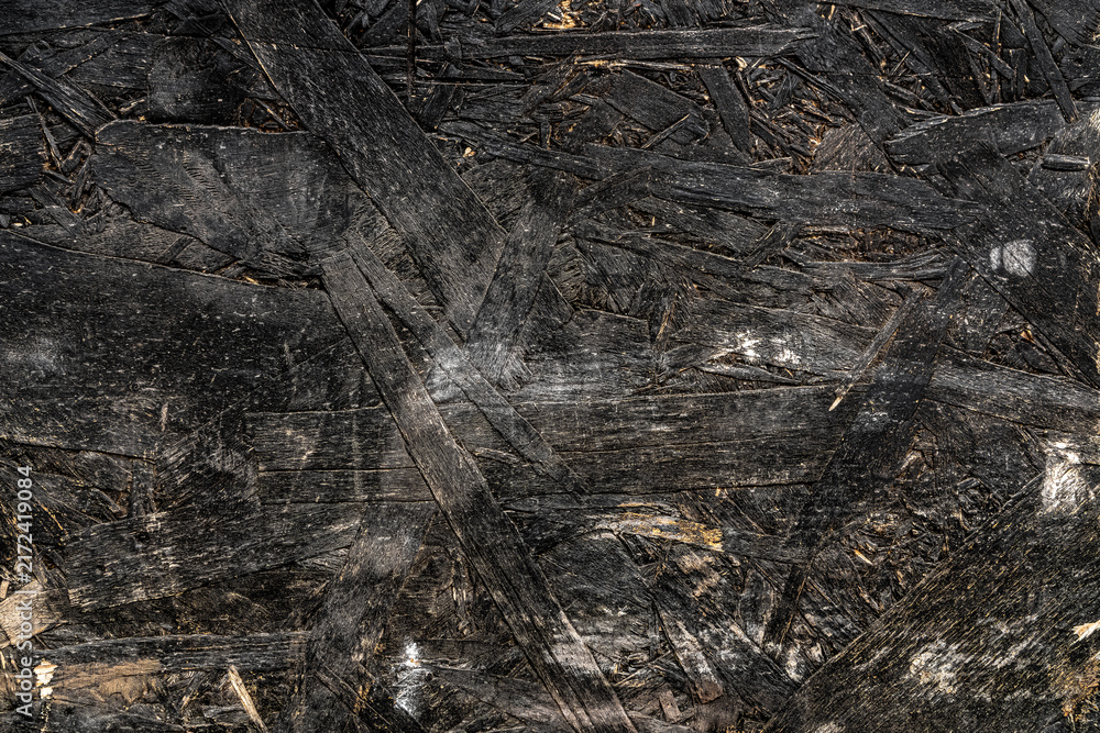 Fototapeta premium Black wooden chipboard texture close up