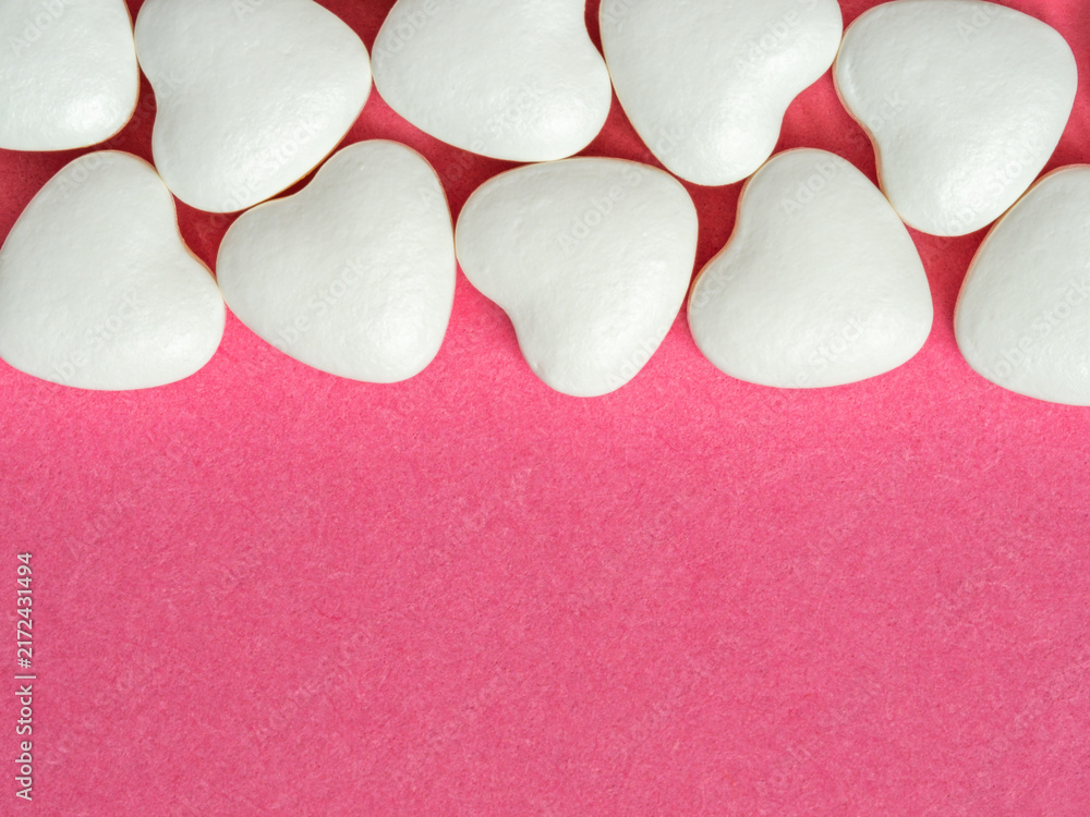 Fototapeta premium White Heart Candies Lined on Pink Background for Valentine Love and Romantic Sweet Concept