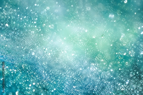 Abstract turquoise and teal glowing water drops bokeh background with wallpaper