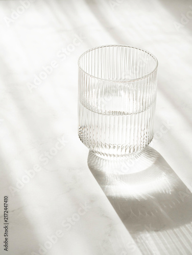 Glass of Water with Dramatic Shadow on White Background