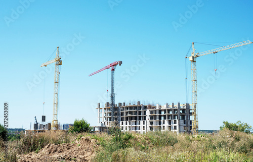Green living and urban development: new apartment complex construction site in a field with wildflowers