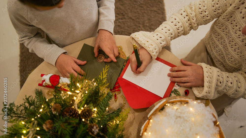 Obraz premium Children writing holiday cards with festive decorations and warm lighting