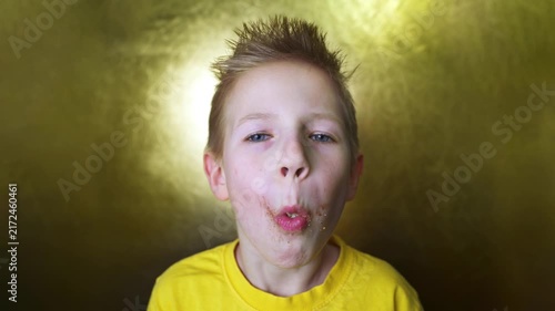 Cheerful blond child with tousled hair enjoys a chocolate-covered donut, creating a playful food portrait with a joyful expression. Concept of childhood treats, sweet cravings, snacks, and indulgence.