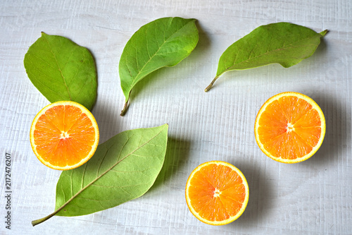Fresh orange fruit with slices and leaf on white background