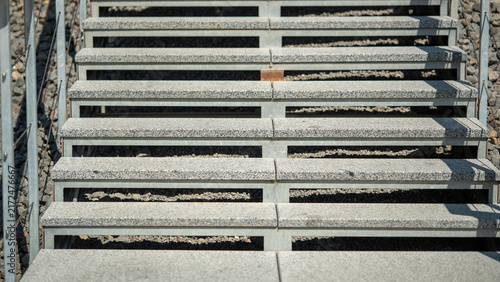 Fotografie Stairs lead down to a gravel area under bright sunlight in an outdoor setting