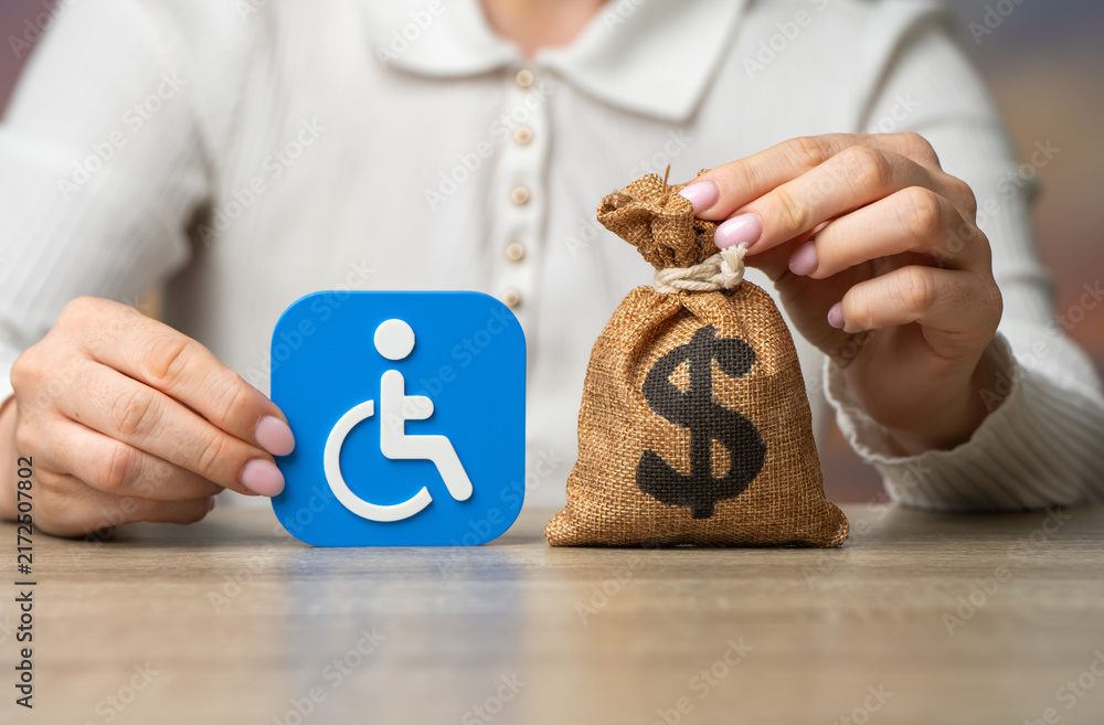 Obraz premium Disability symbol and dollar money bag. Compensation for health damage, medical treatment grants, pensions and benefits. Social support and financial assistance.