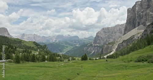 Green alpine valley beneath rocky Dolomite peaks in Italy