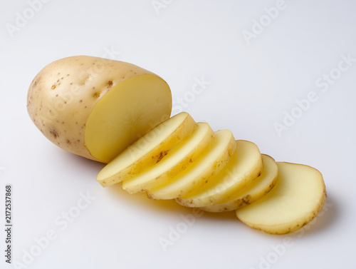 Aufgeschnittene rohe Kartoffel mit mehreren gleichmäßigen Scheiben auf weißem Hintergrund. Frische Lebensmittel, Gemüse, Kochen, Küchenvorbereitung und neutrale Food-Fotografie.