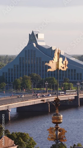 An elevated view across the Daugava river towards Akmens Bridge and the National Library of Latvia in Riga with decorative spire details.