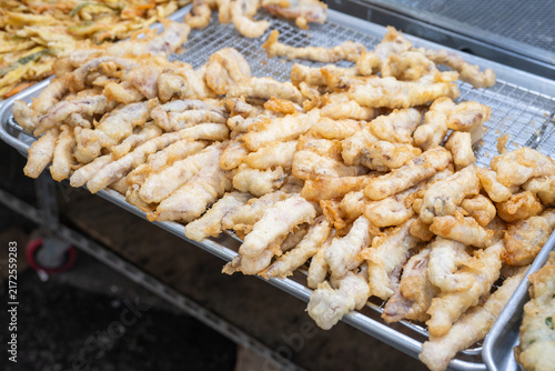 Photography Close up view of freshly cooked crispy deep fried squid fritters stacked high at a local traditional market food stall