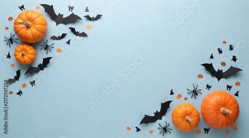 A festive flat lay composition featuring orange pumpkins and spooky Halloween themed paper decorations