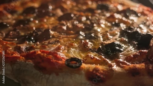 A close-up shot captures a freshly baked pizza baking inside a hot oven, highlighting the bubbling melted cheese and glossy texture under warm lighting.