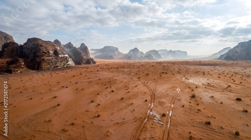 Aerial view of sandy desert flatlands under cloudy sky

