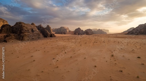 Vast sandy desert plain surrounded by distant rocky mountains
