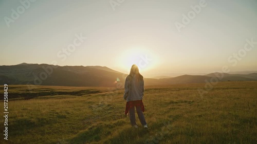 Sunset walk in open field with dog near mountains in warm afternoon