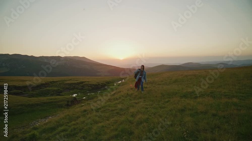 Sunset walk on a hillside with a person enjoying nature and the view in a green landscape